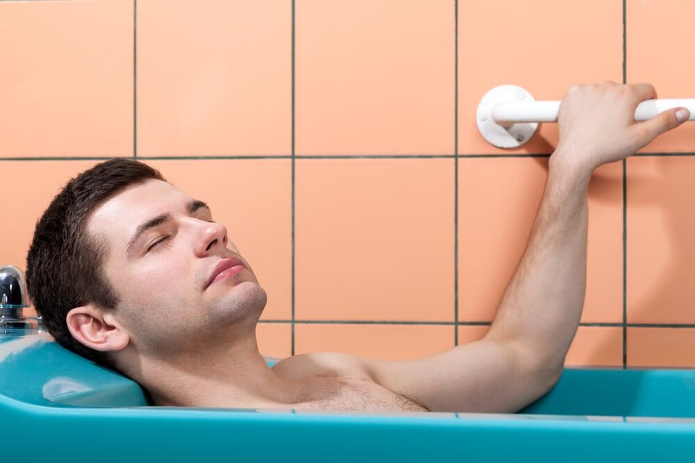 A man bathes with baking soda to enlarge his penis